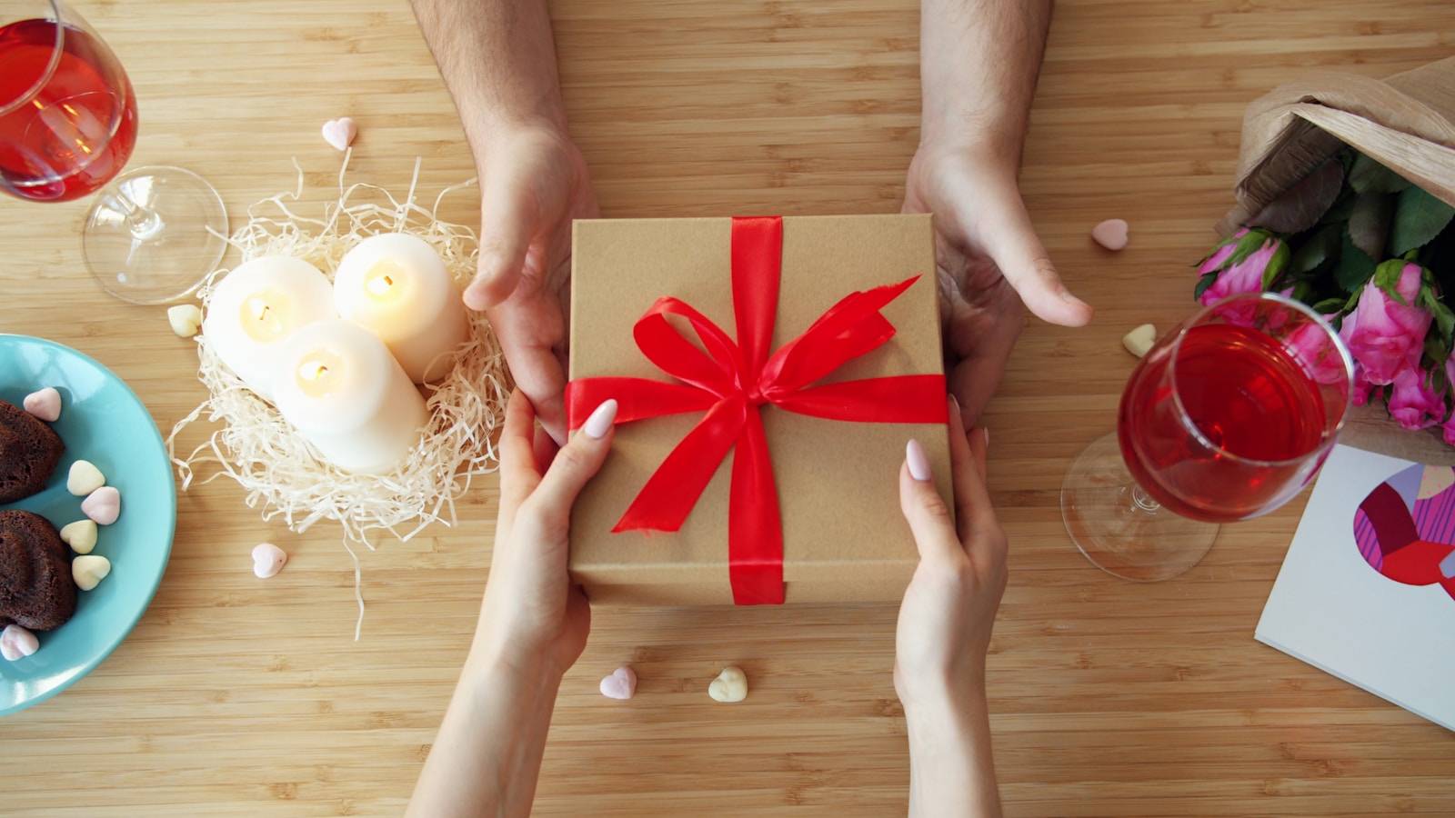 A real low-pressure romantic gift exchange scene with a wrapped present and table setting.