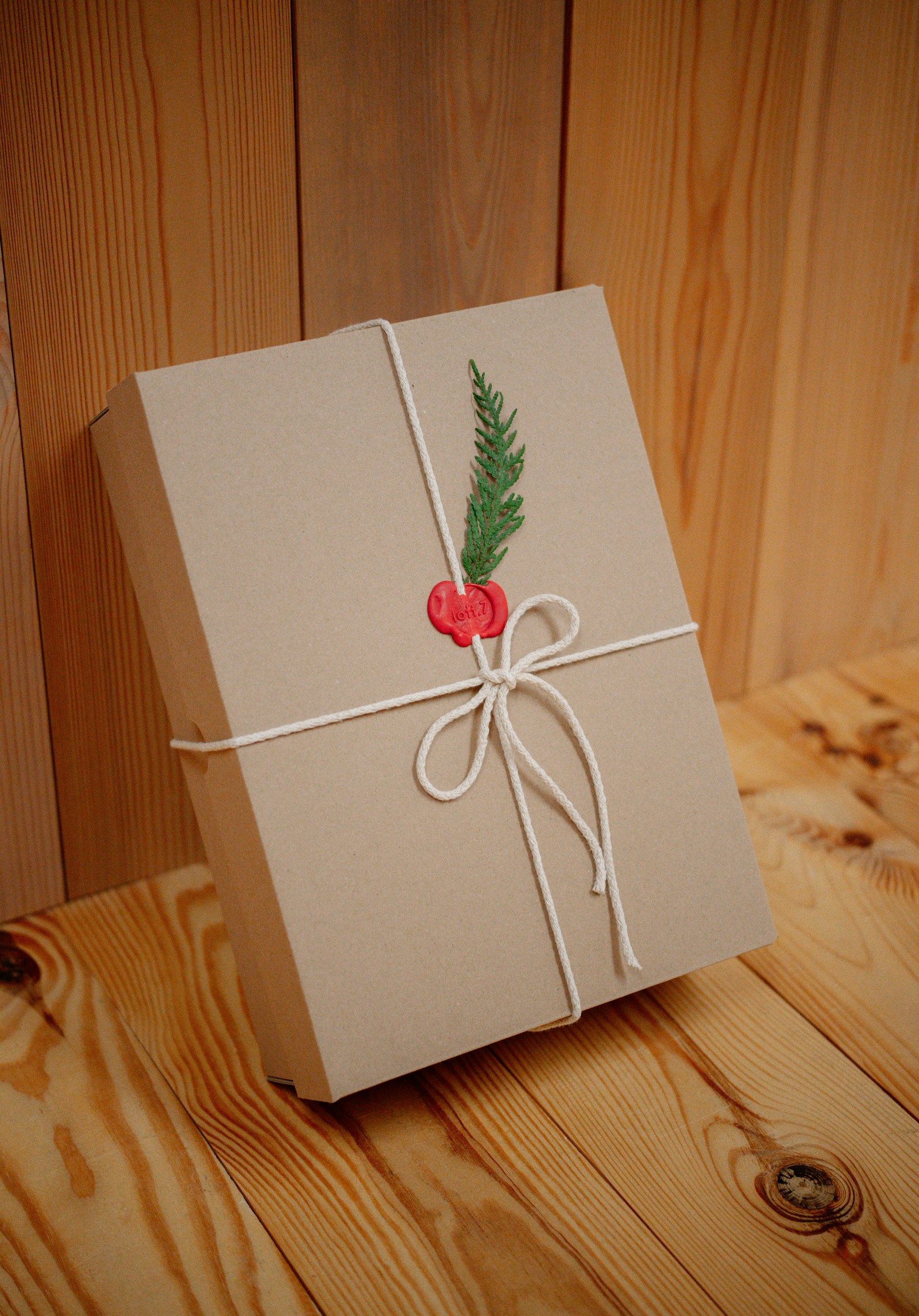 A real kraft paper gift box tied with string, suitable for a care package or mailed gift.