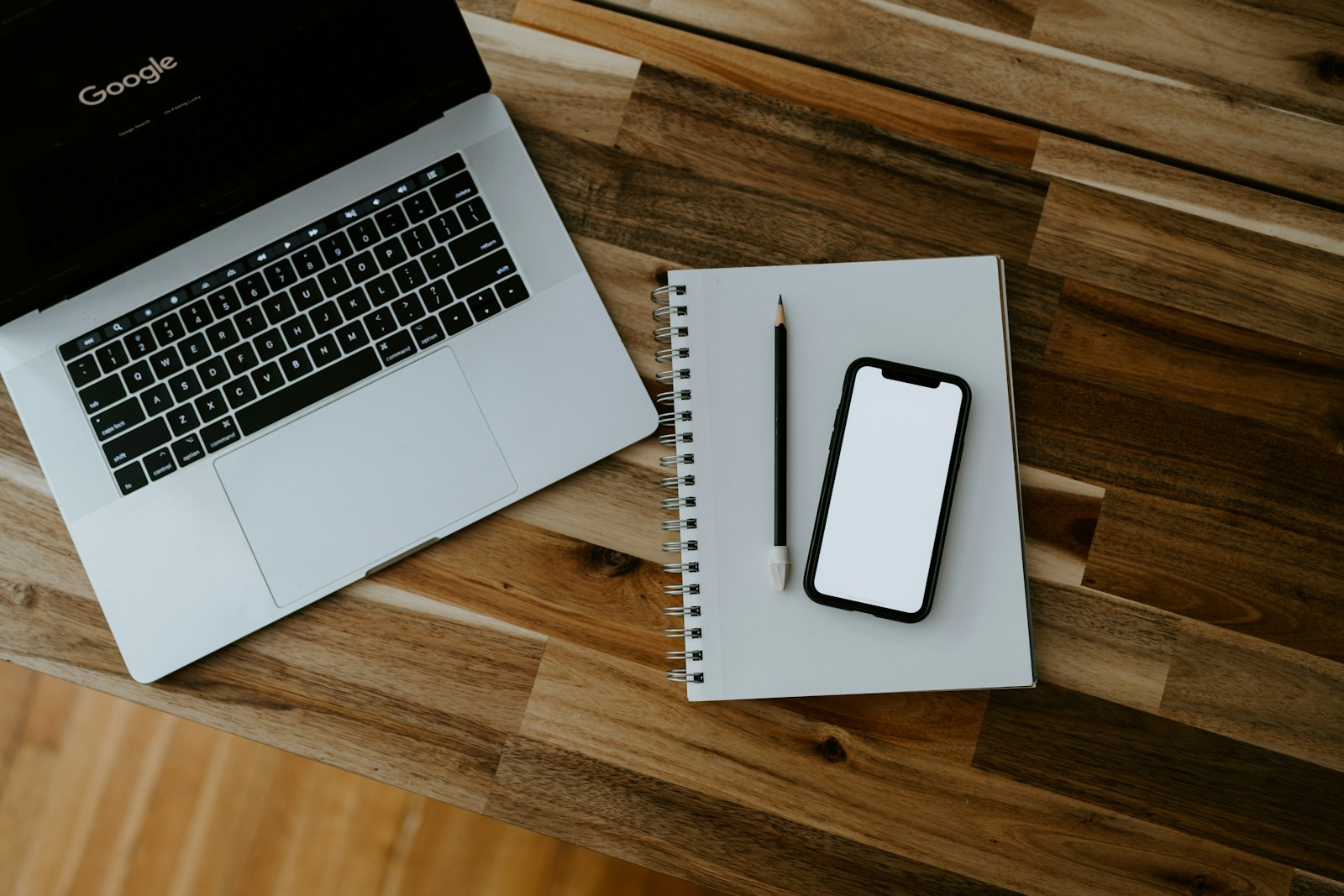 A real laptop and phone workspace scene used as a practical reference for social background assets.